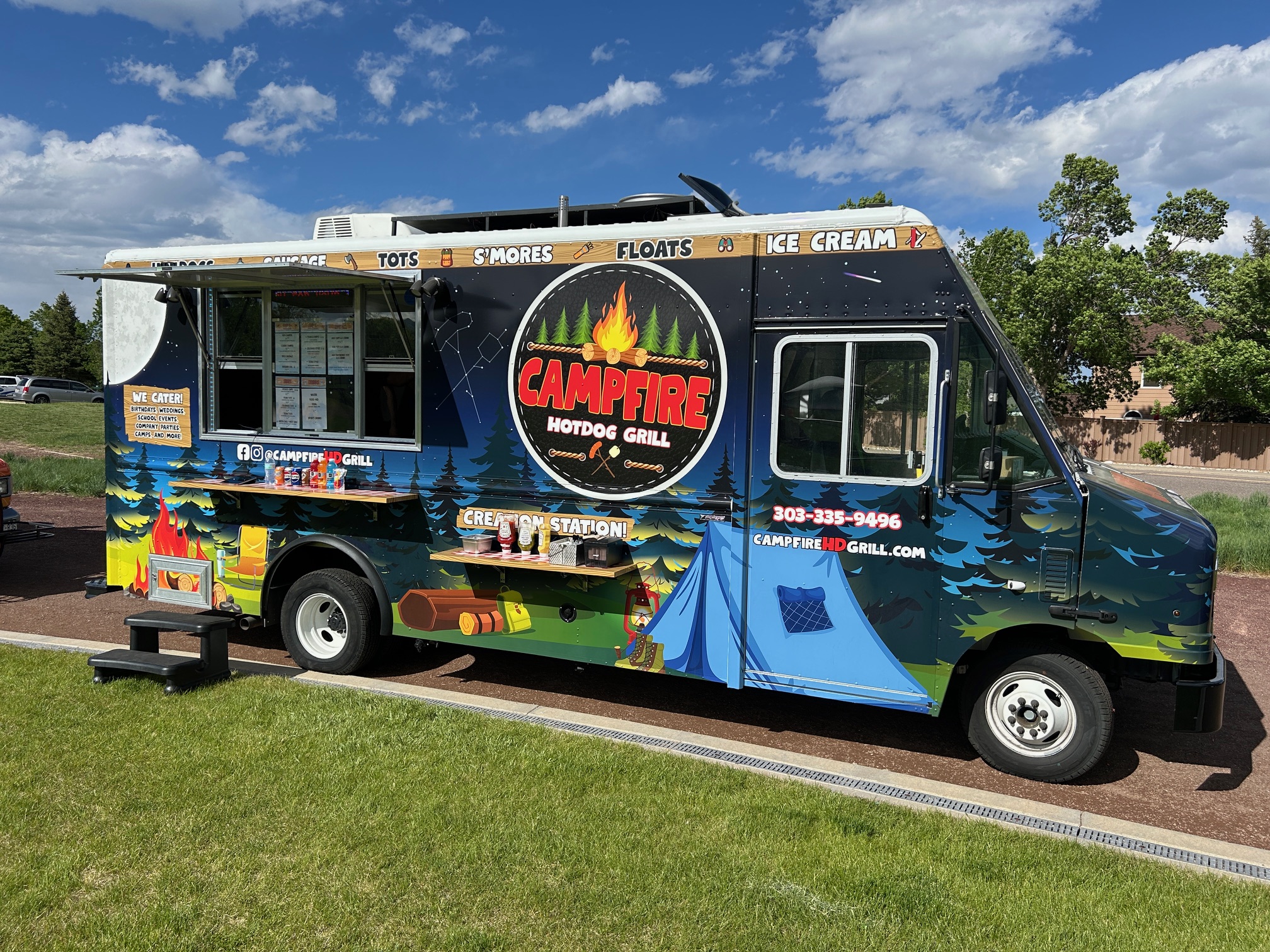 Colorful food truck offering hot dogs, s'mores, and ice cream.