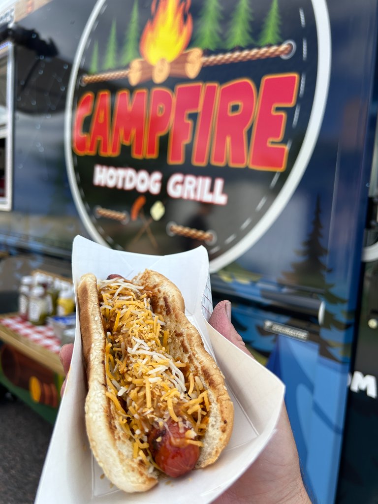Chili cheese dog served fresh in front of the Campfire Hotdog Grill truck.