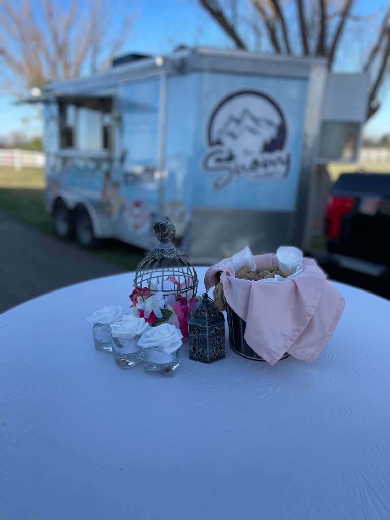 Snowy Churro trailer at a private event with elegant tabletop decor.