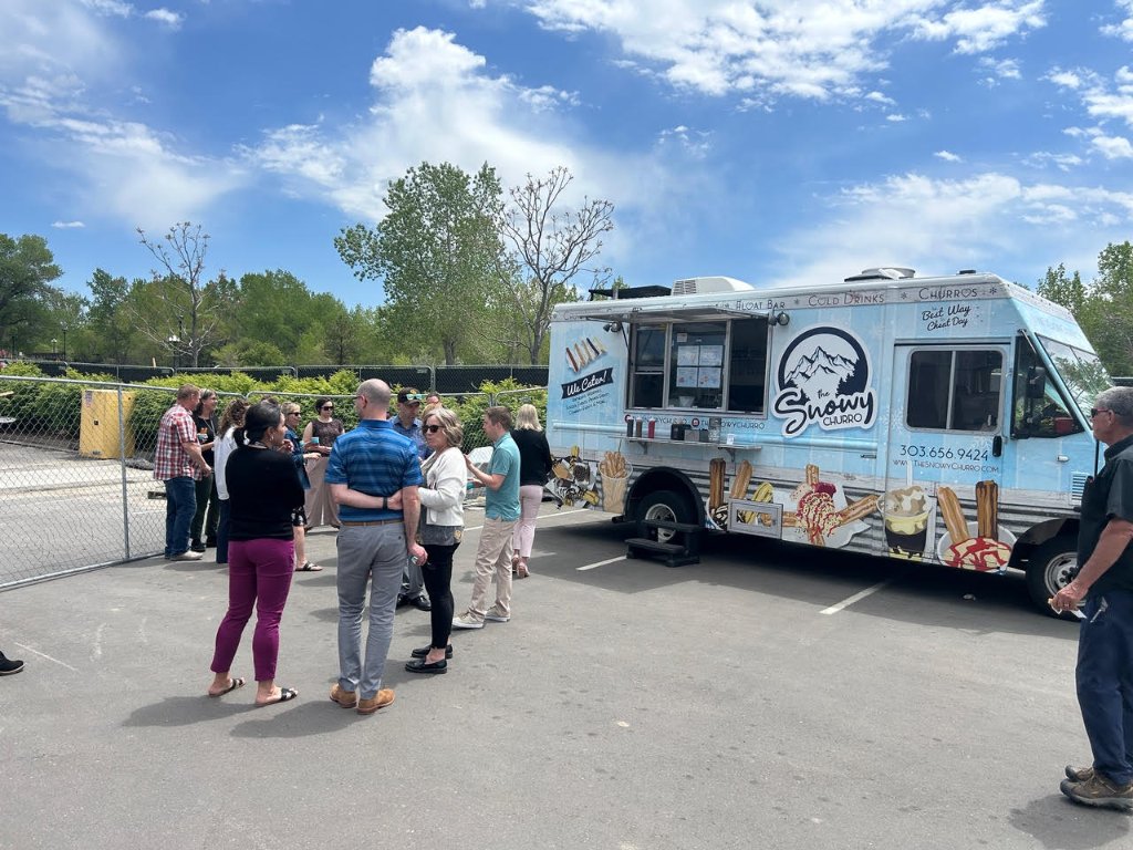 Variety of Snowy Churro desserts, sundaes, and root beer floats spread on a picnic table.