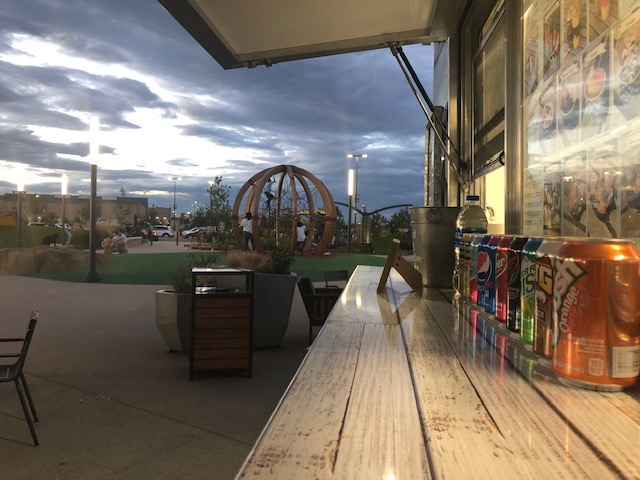 Service window view at dusk with drinks lined up for guests.