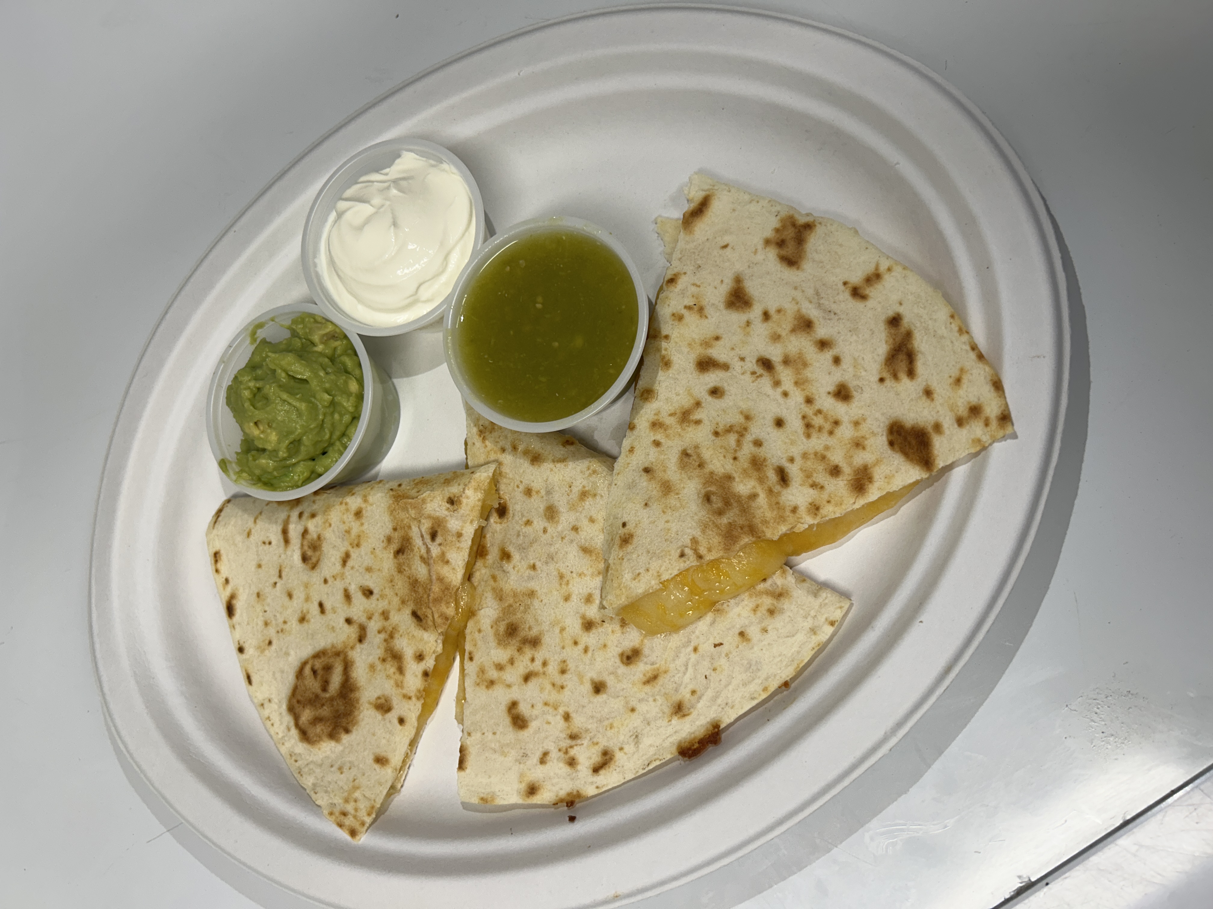 Delicious quesadilla served with guacamole and sauces.