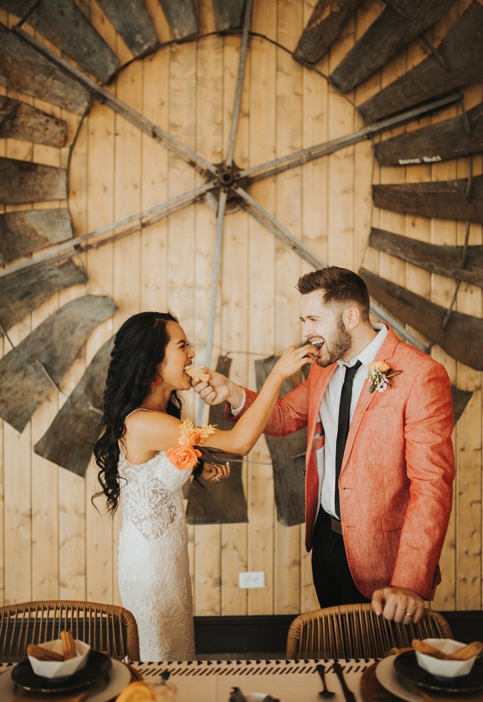 Couple feeding each other churros at their wedding reception.