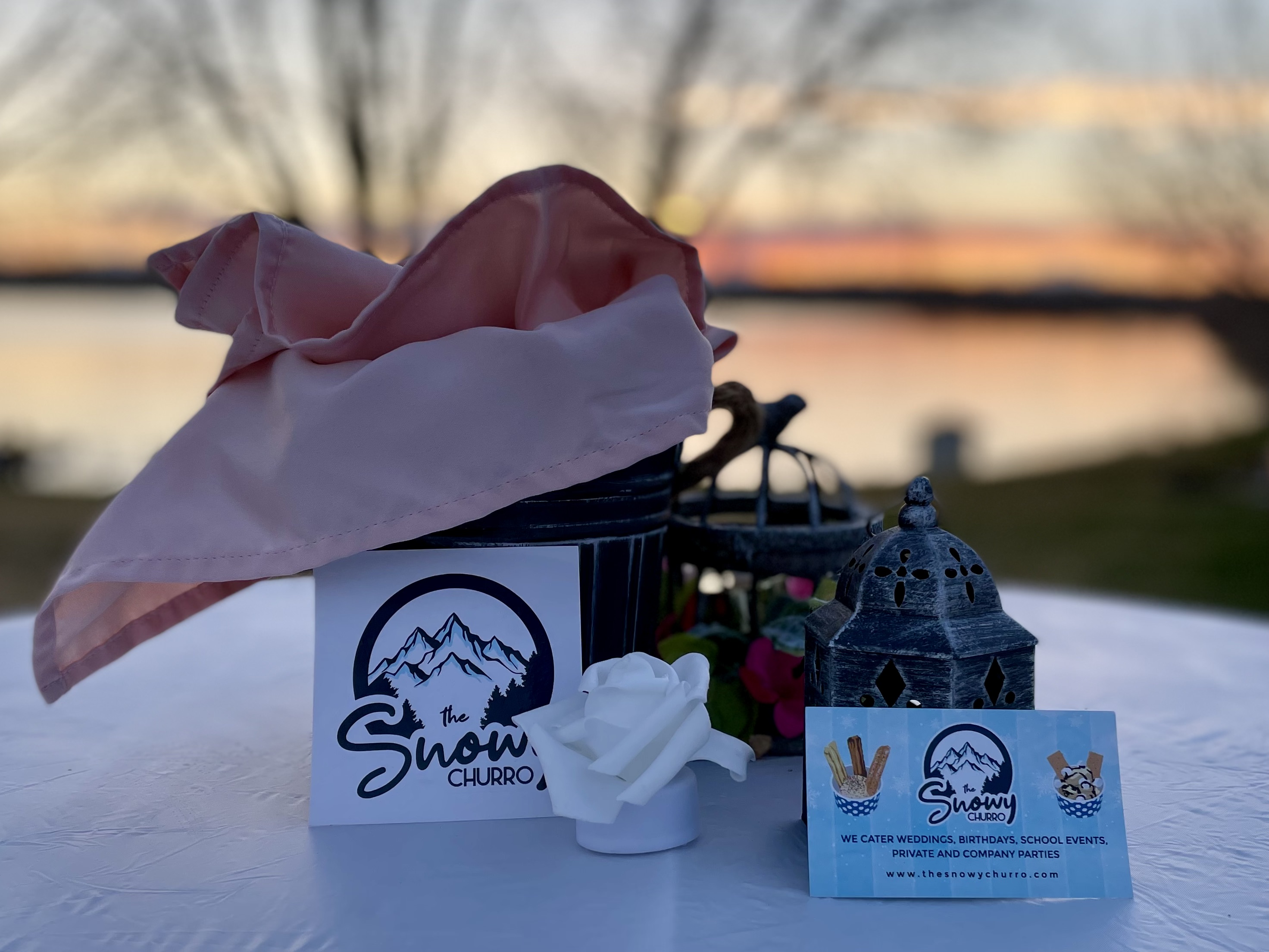 Charming food truck setup by the lake at sunset.